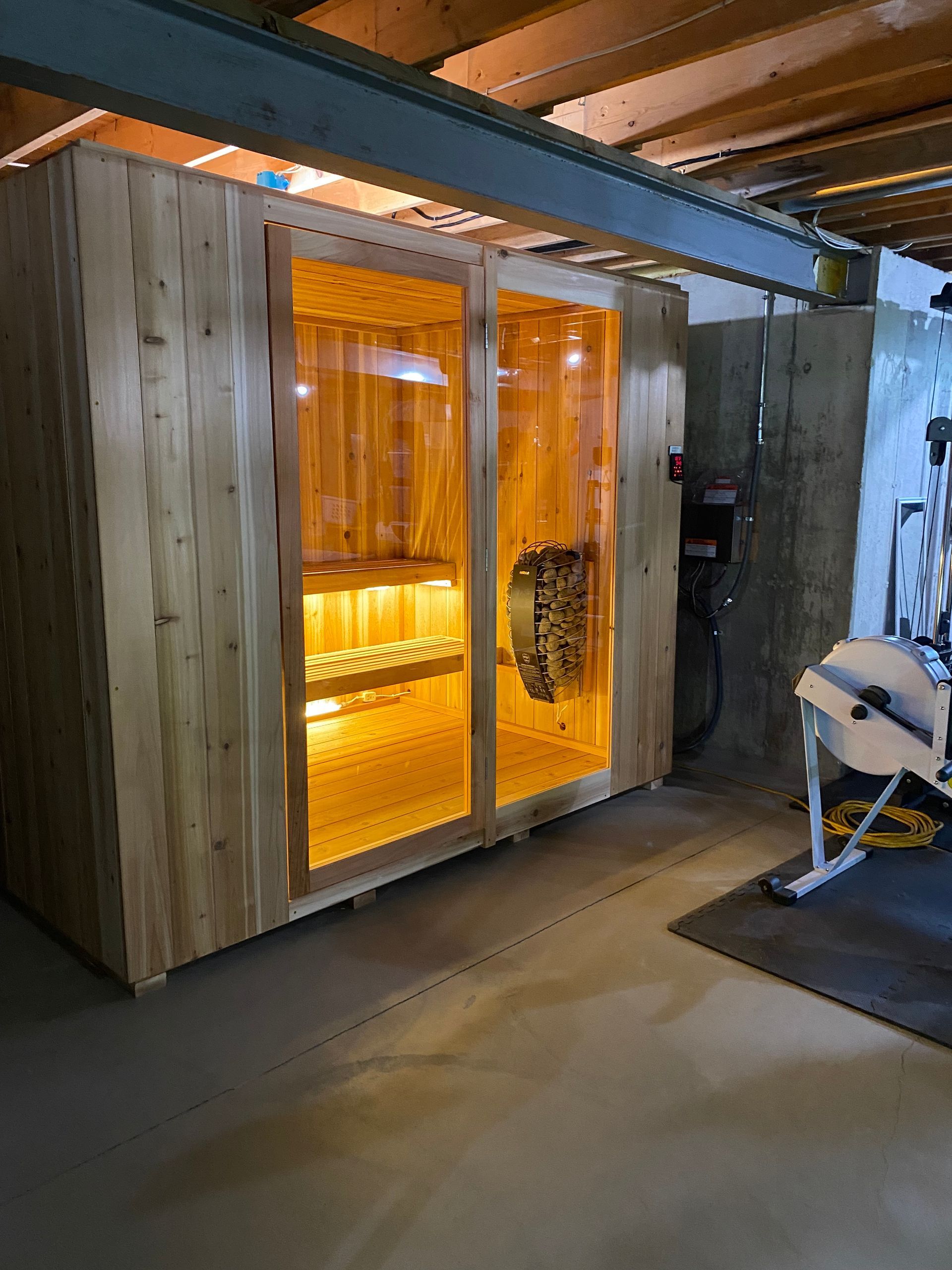 Wooden sauna cabin with glowing orange interior in an industrial indoor space