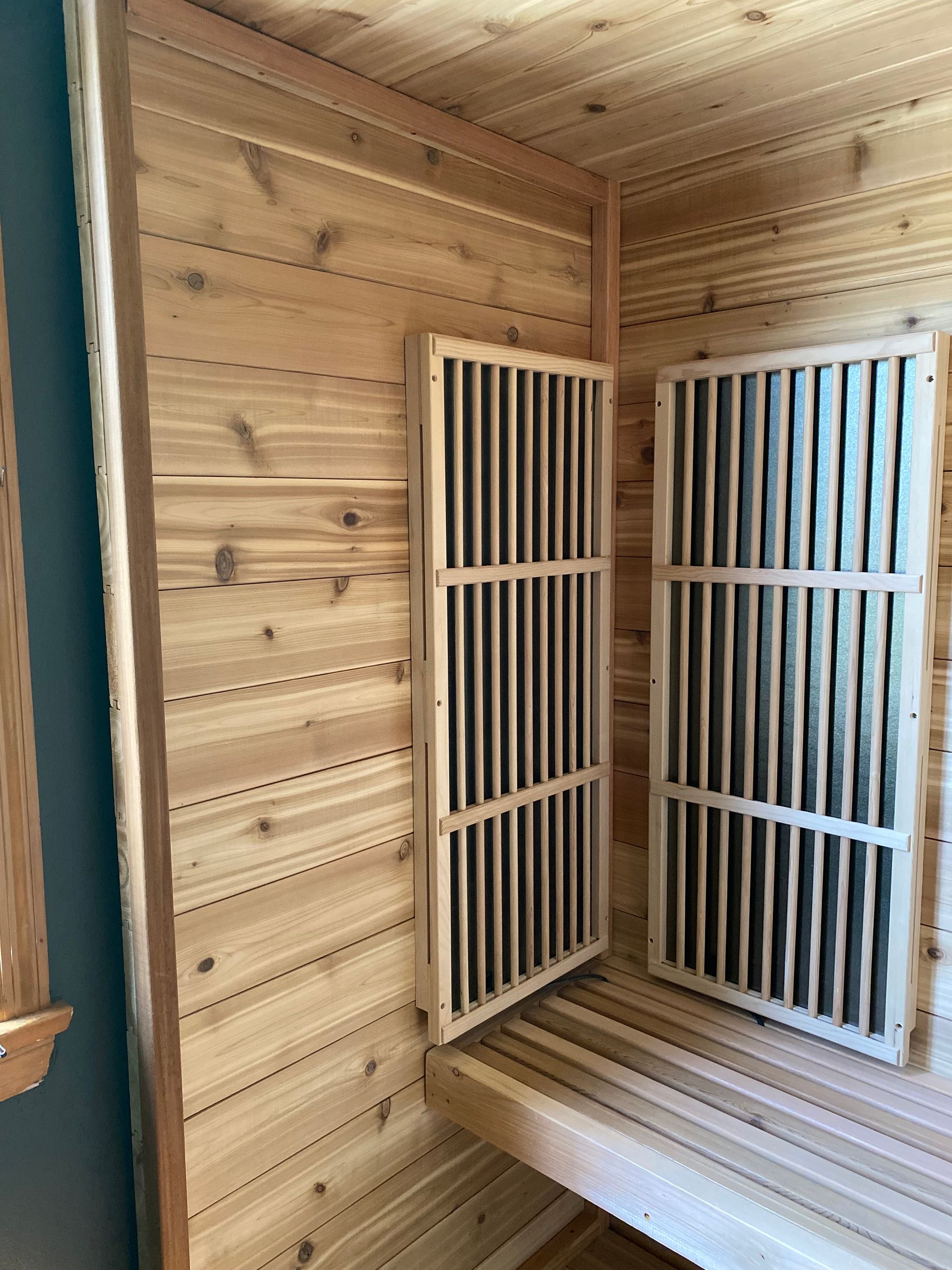 Wood-paneled room with two white barred doors and a built-in wooden bench