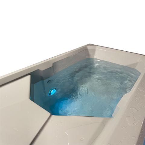 White hot tub with blue-lit bubbling water in a corner spa setting