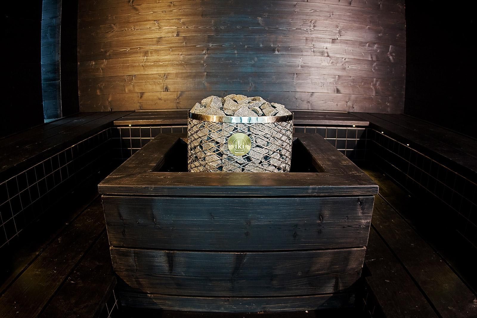 Dark wooden chest with a smaller stone-filled box centered inside, in a dimly lit room.