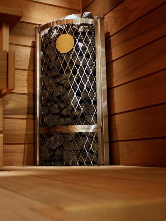 Wood-paneled sauna with bench seating and a glowing heater in the corner
