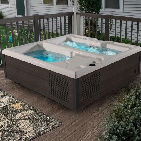 Outdoor plunge tub with turquoise water on a wooden deck beside a railing and patio rug.