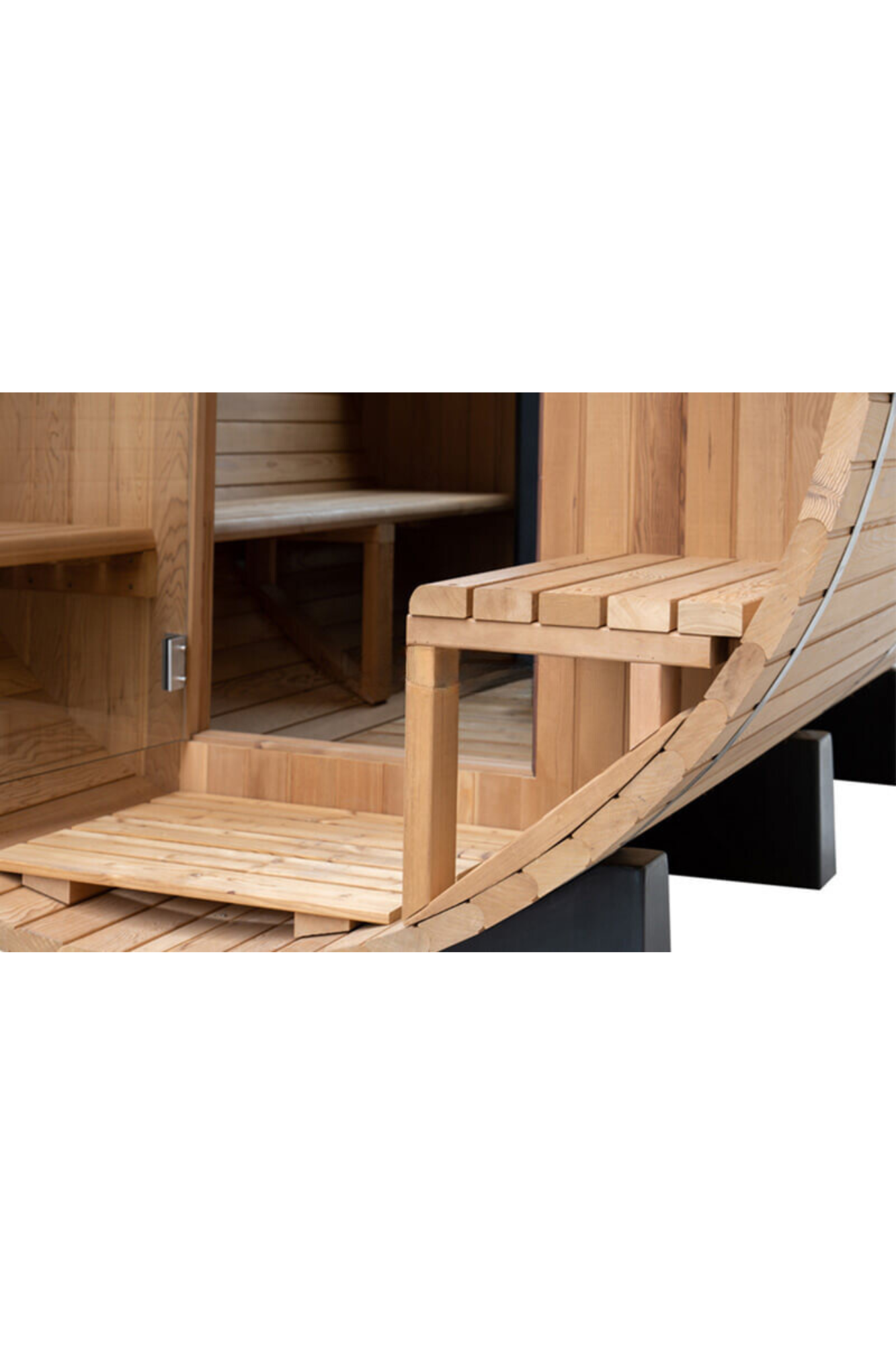 Wooden sauna interior with benches, slatted floor, and a curved lounge chair by a heated wall.