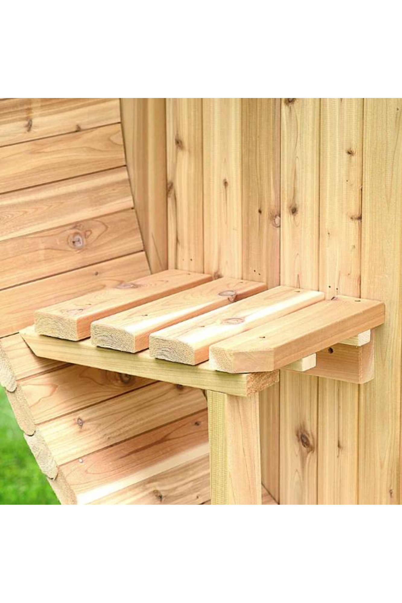 Wooden bird feeder mounted on a tree trunk beside a wooden fence.