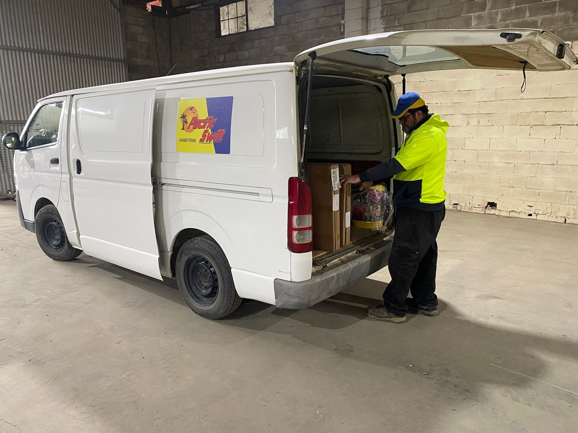 Man Unpacking Van With Boxes Inside — Professional Transport in Forster, NSW