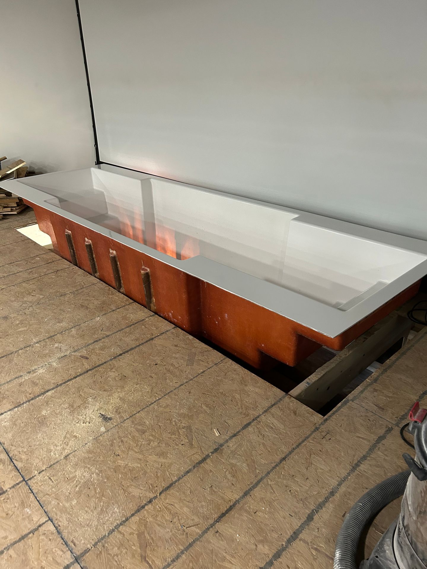 Built-in glass-topped display case in a tan-tiled floor area, with a wood base against a wall.