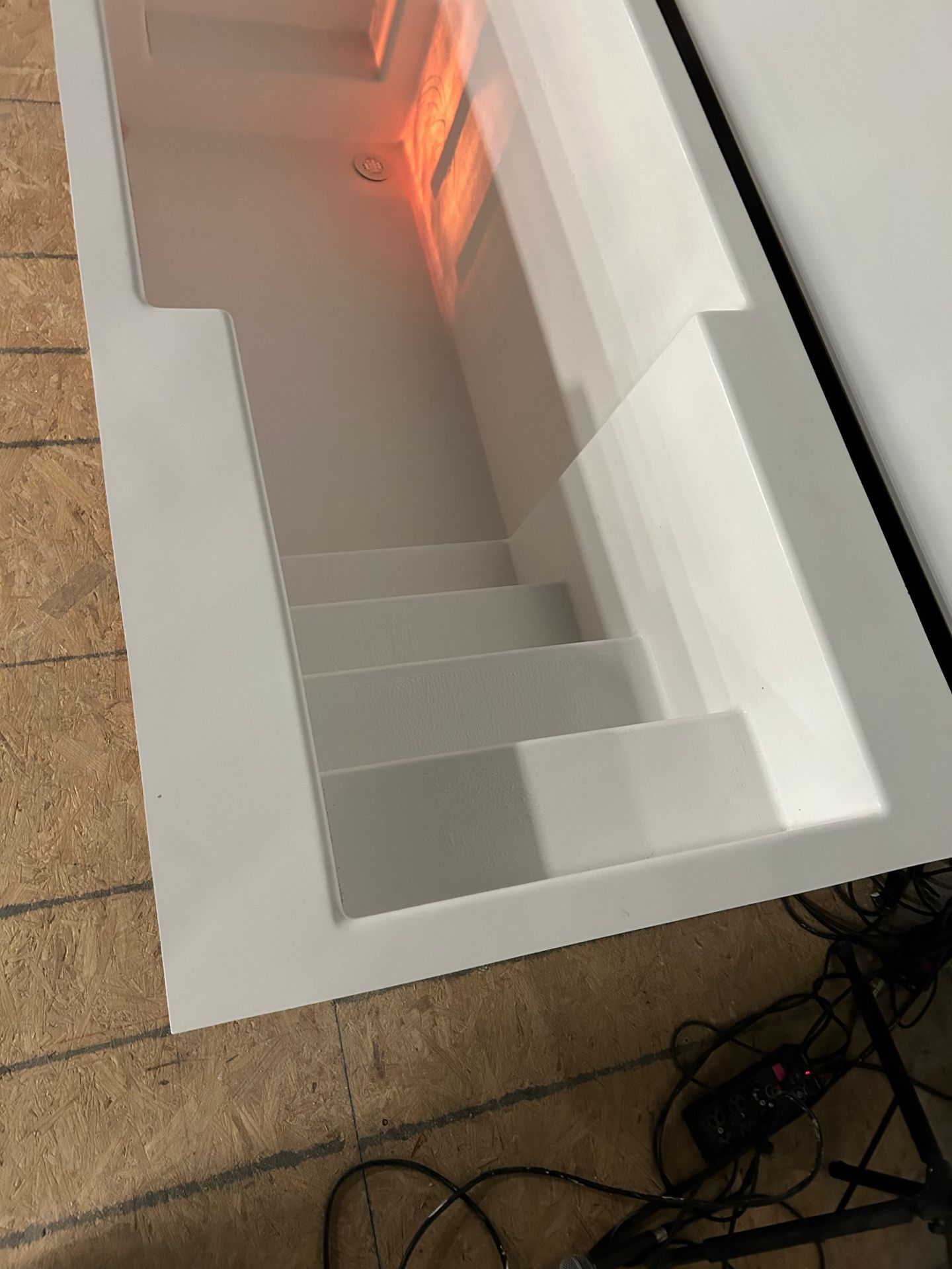 White stair display with orange lighting in a room, viewed from above
