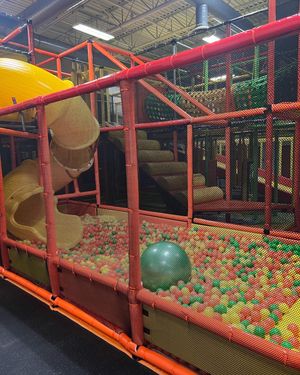A children 's playground with a slide and a ball pit.