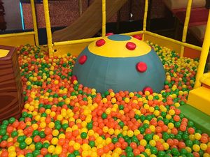 A ball pit filled with colorful plastic balls in a playground.