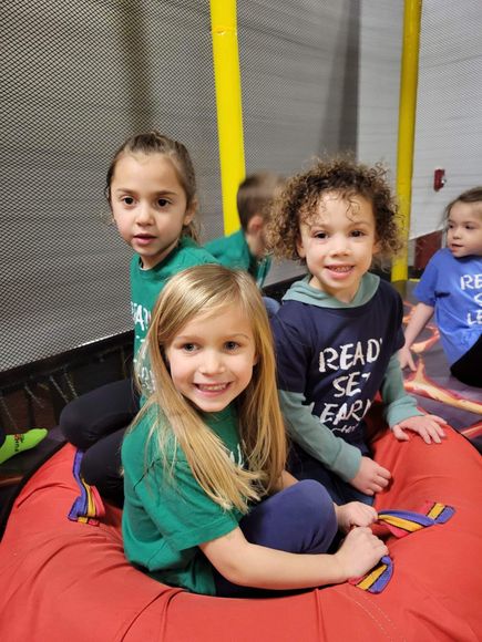 A group of young children are sitting on a bean bag chair.