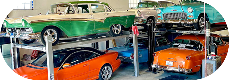 Classic colorful cars displayed on stacked ramps in a showroom | Clark's Tire Automotive