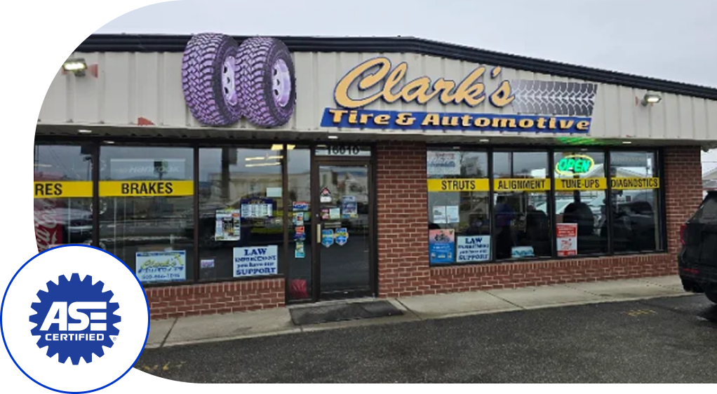 Clark's Cafe and Electronics storefront with purple donut sign and wet parking lot under a gray sky  | Clark's Tire & Automotive