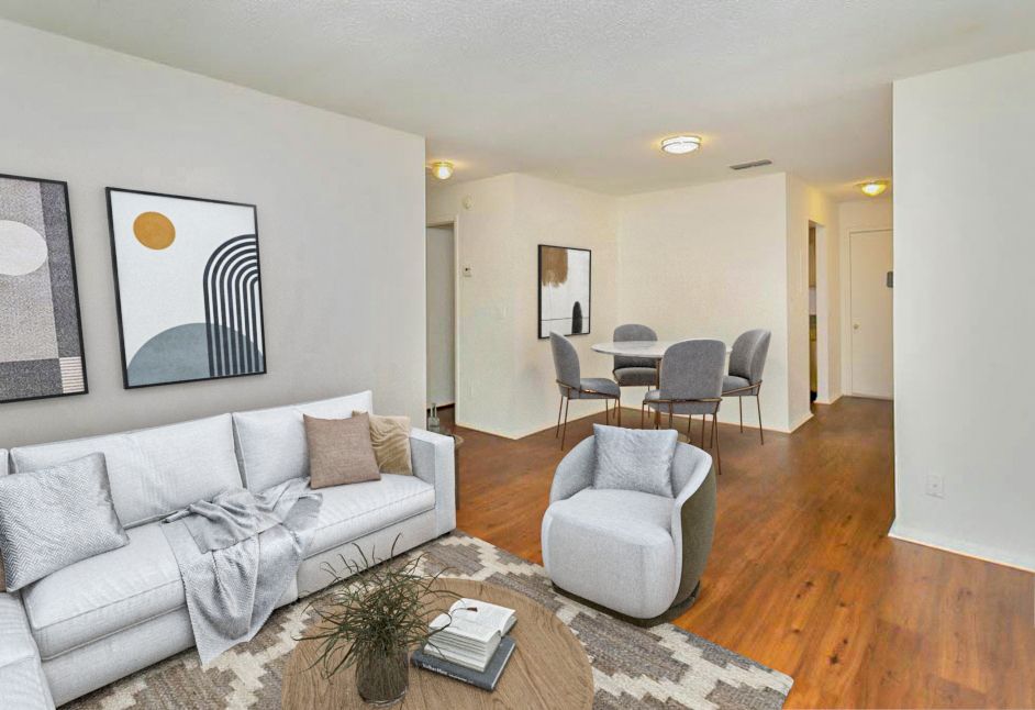 Living room with white sofa, art, and a round dining table with chairs.