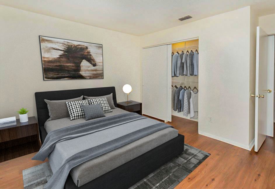 Bedroom with bed, closet, art, nightstand, and rug.