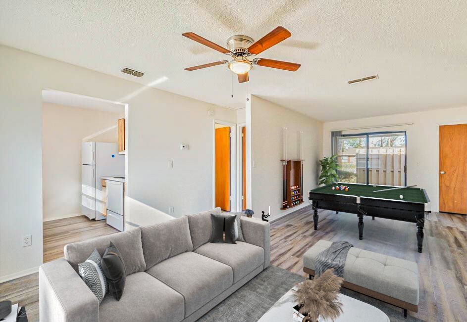 Living room with a gray sofa, pool table, and wood-look flooring.