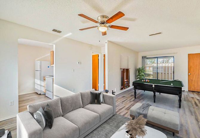 Living room with a gray sofa, pool table, and wood-look flooring.