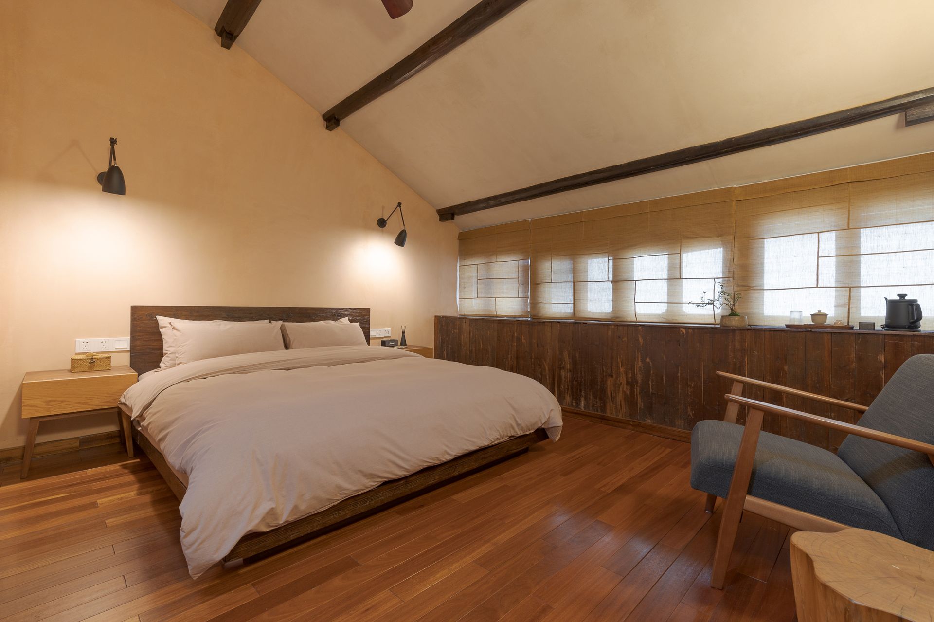 Cozy bedroom with a large bed, wooden floors, and slanted ceiling windows.