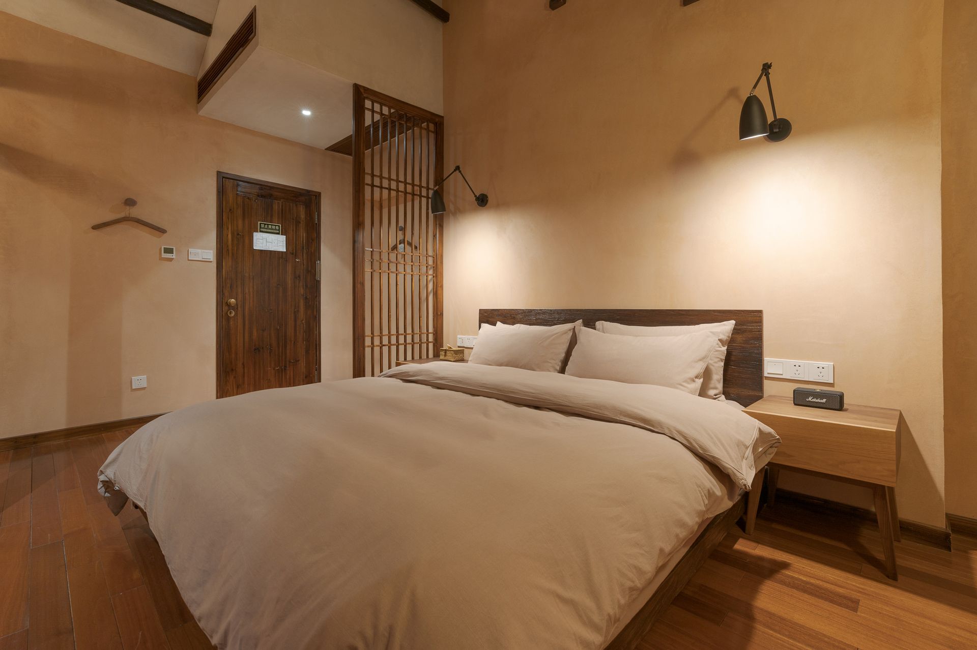 Cozy beige bedroom with a large bed, wooden headboard, and warm lighting.