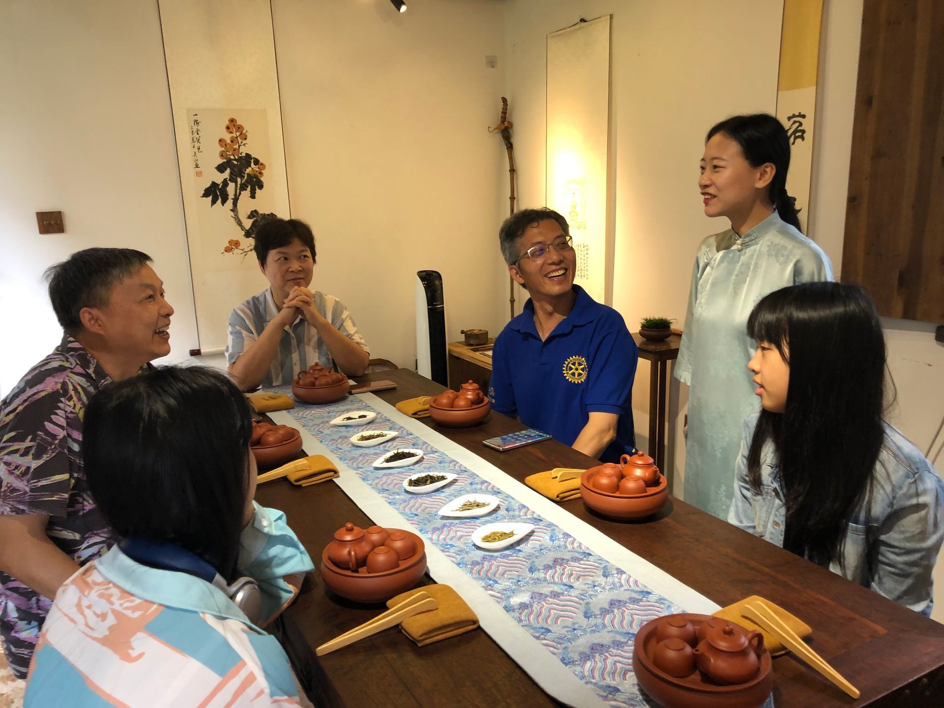 People sharing tea and snacks around a table in a bright dining room