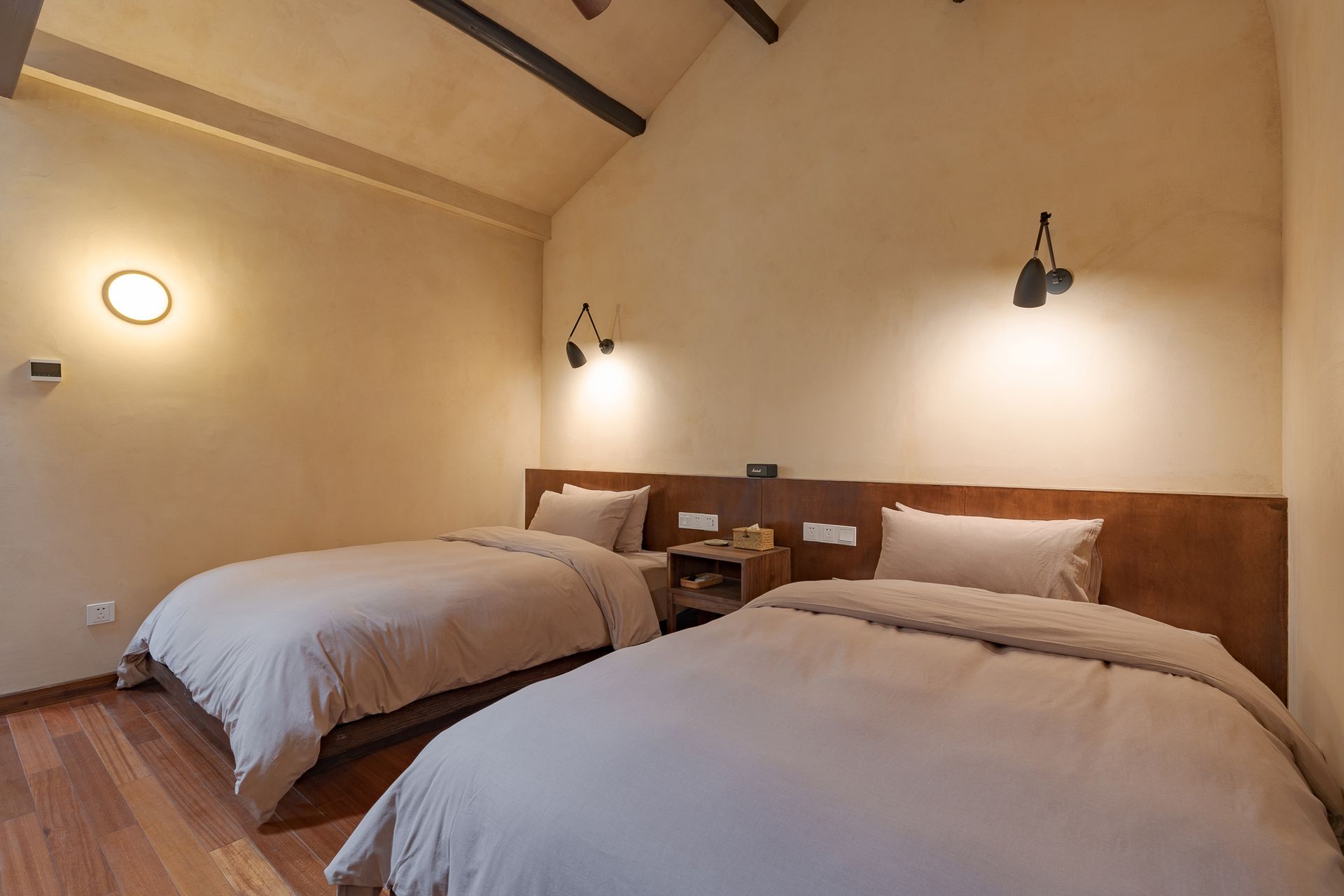 Cozy bedroom with two twin beds, warm lighting, and wooden accents