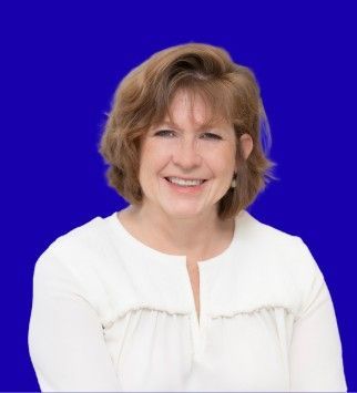 Smiling woman in a white blouse against a solid blue background