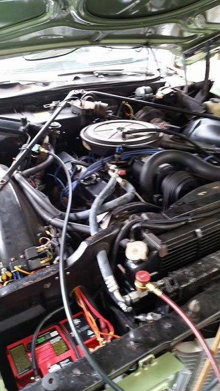 A close up of a car engine with the hood open.