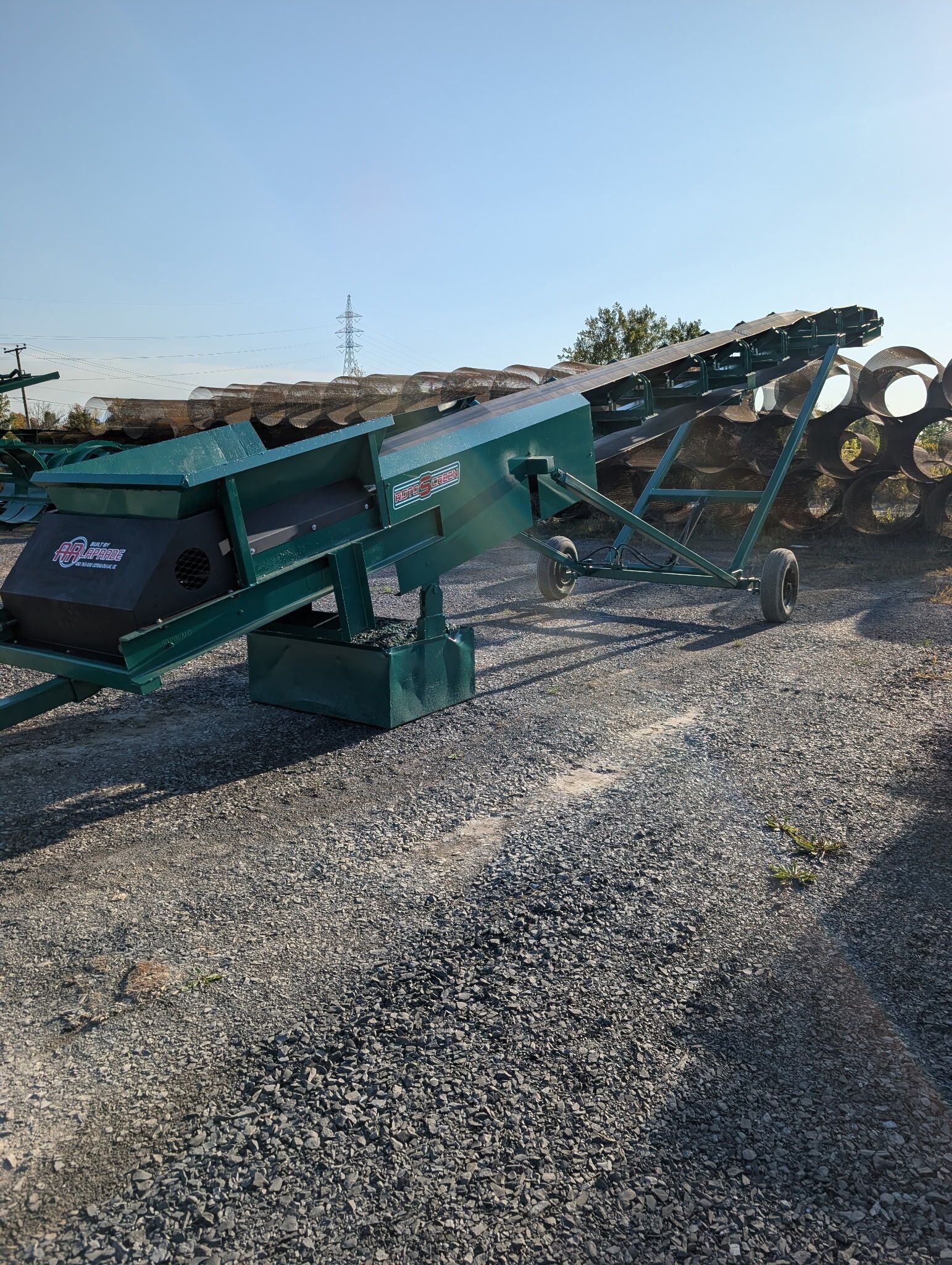 Green conveyor belt machine on gravel.