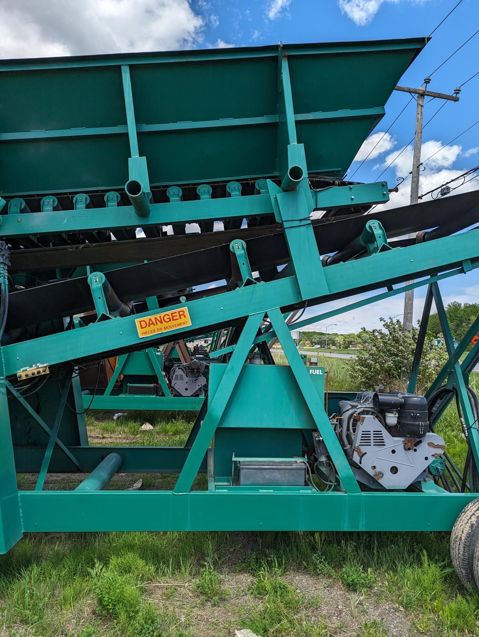 A green machine is parked in a grassy field.