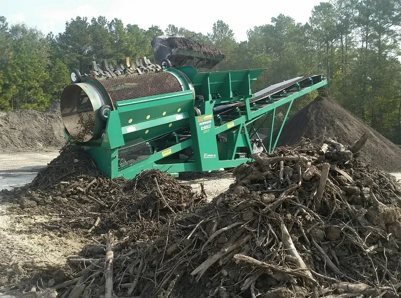 Crible rotatif industriel vert pour le tri des composts et des débris en extérieur.