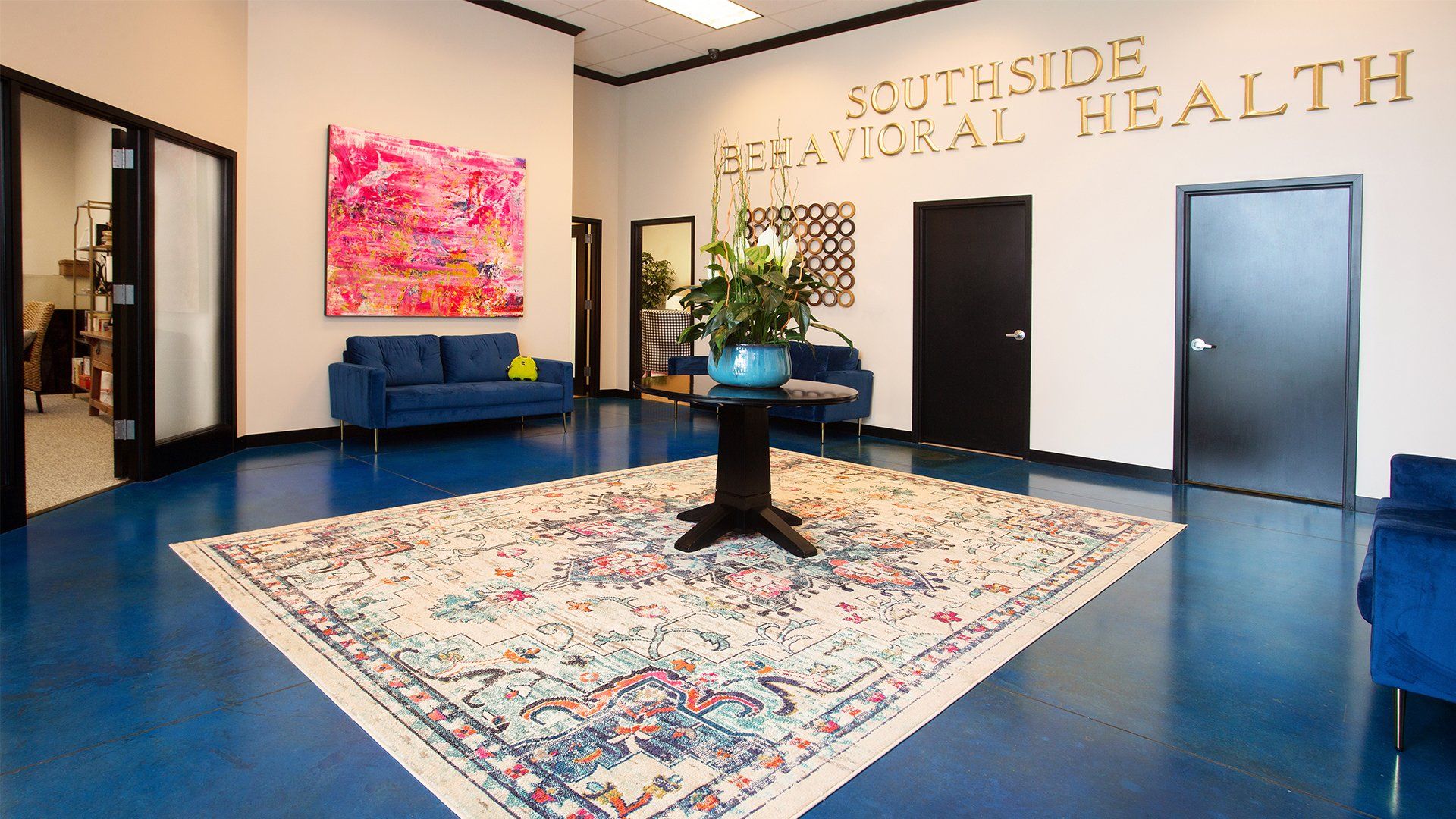 A waiting room with a rug and a couch and a sign that says southside health