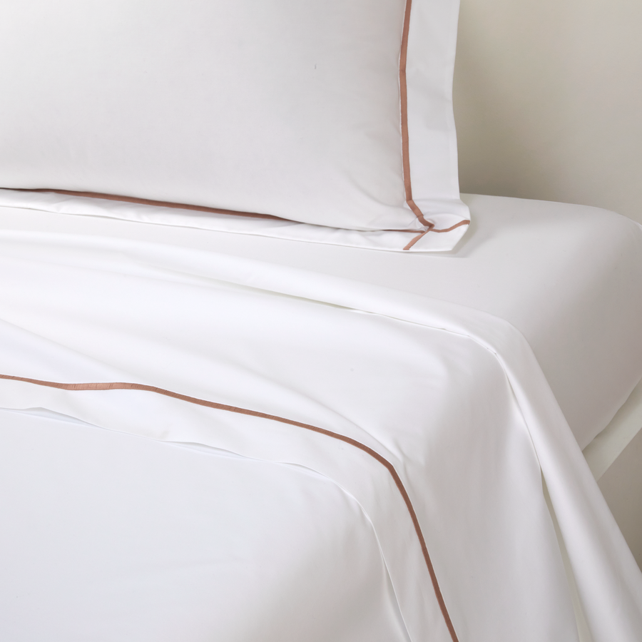 Un lit avec des draps blancs et des oreillers dessus
