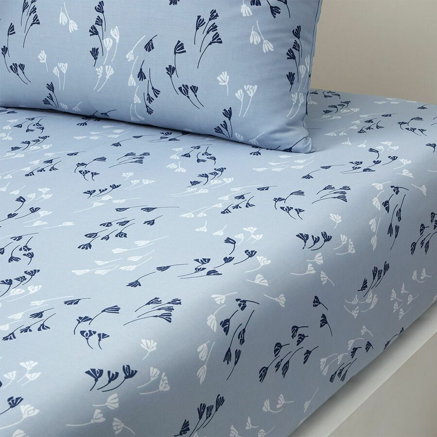 Drap-housse et taie d'oreiller bleu clair à motif botanique abstrait bleu foncé et blanc.