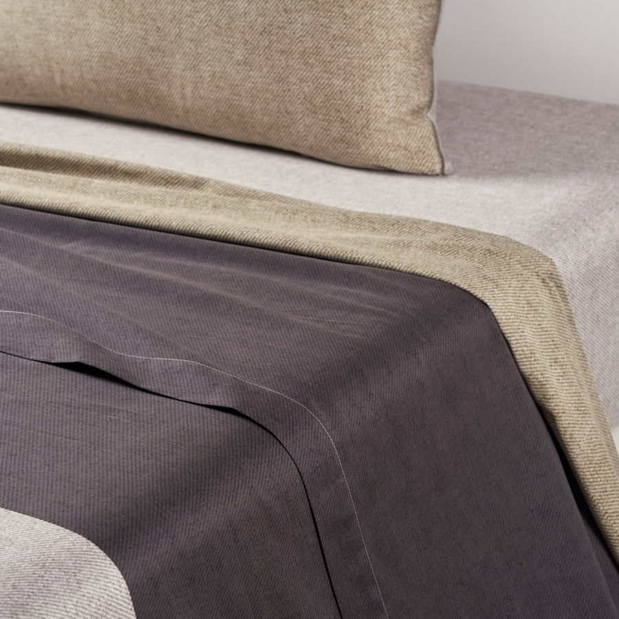 Un lit avec une couverture et des oreillers dessus