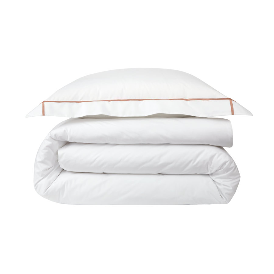 Une couette et un oreiller blancs sont empilés l'un sur l'autre