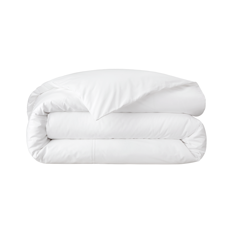 Une couette blanche est empilée les unes sur les autres sur un fond blanc.