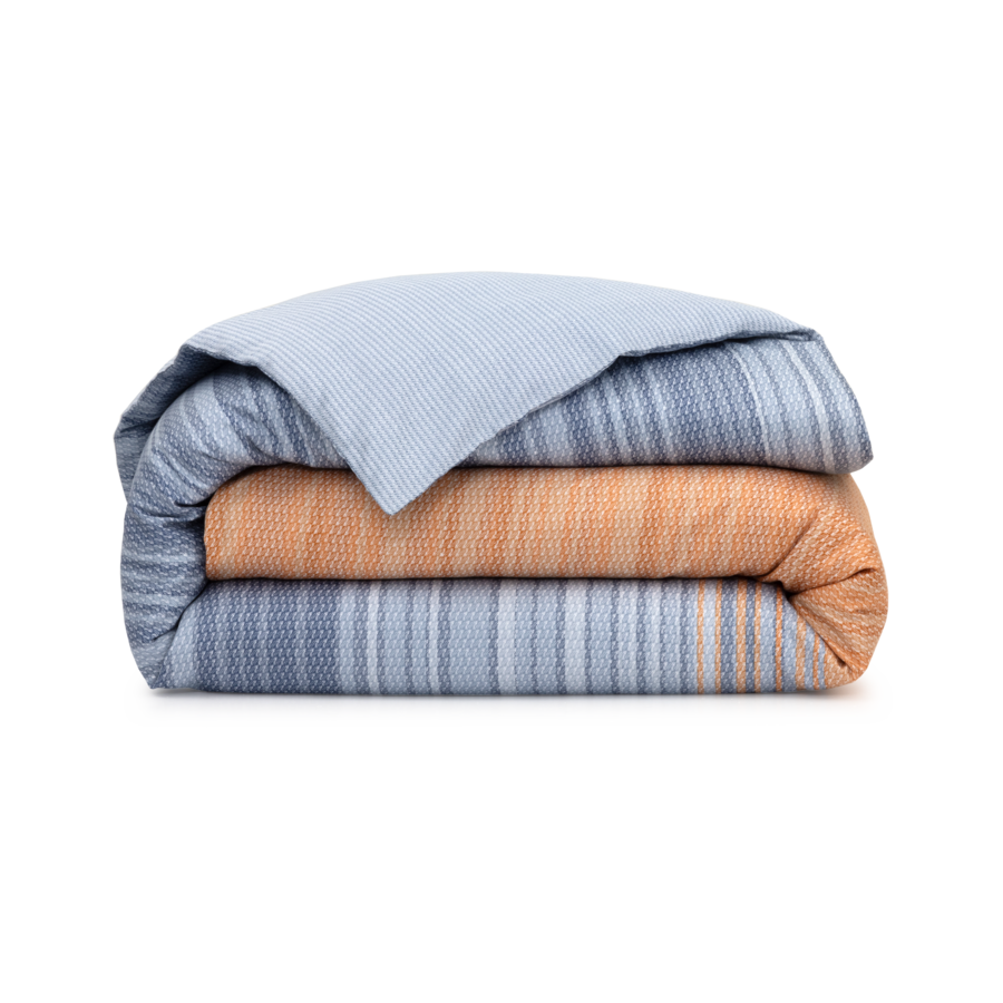Une couette à rayures bleues et orange est empilée l'une sur l'autre