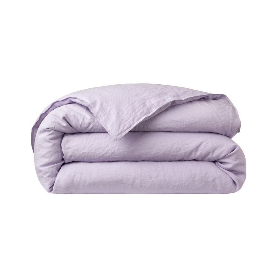 Une couette violette est empilée les unes sur les autres sur un fond blanc.