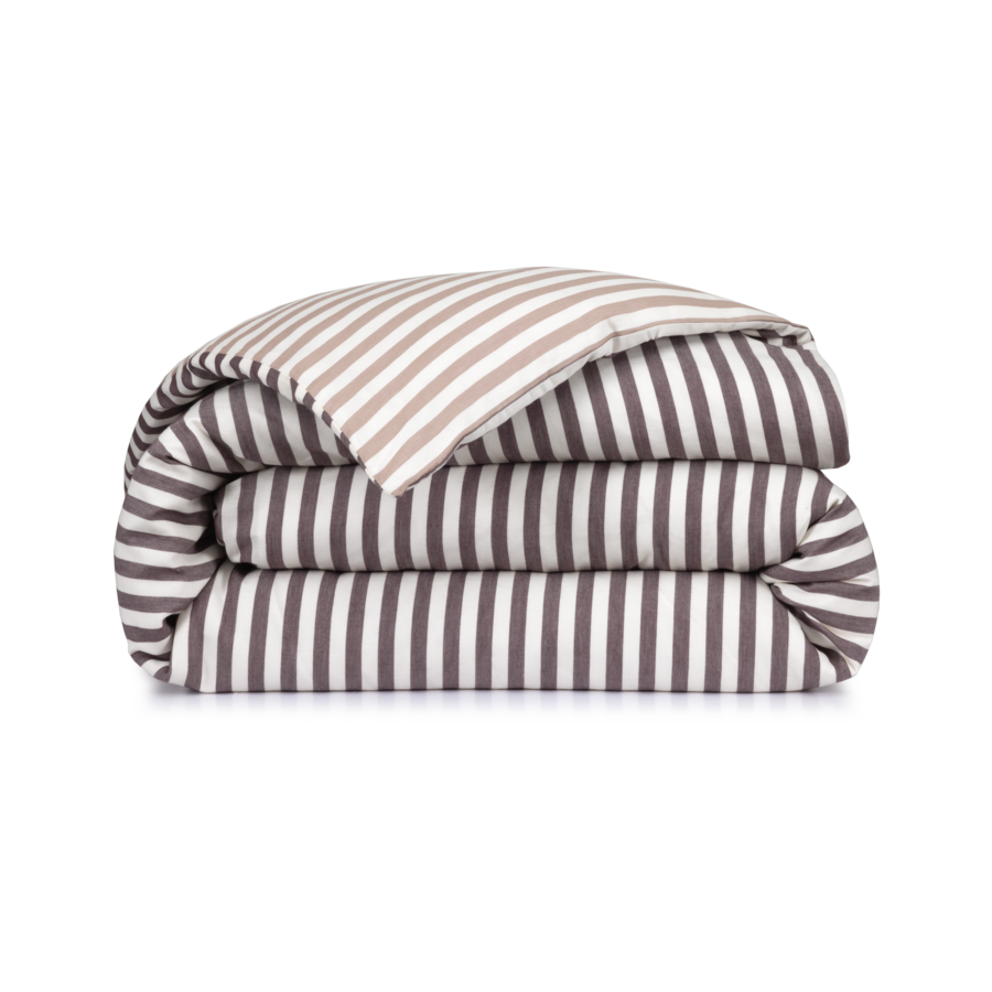 Linge de lit rayé beige et gris plié et empilé sur un fond blanc