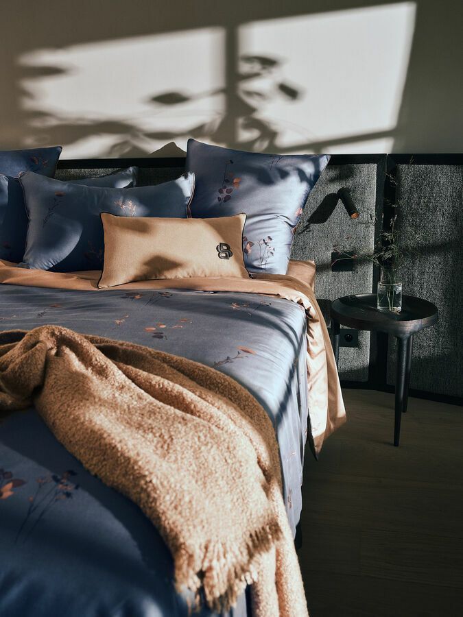 Un lit avec une couverture et des oreillers dessus dans une chambre.
