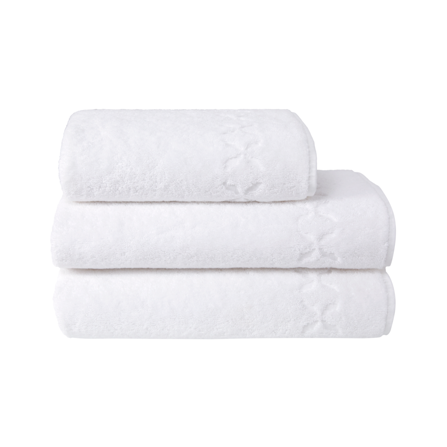 Trois serviettes de bain blanches empilées les unes sur les autres, ornées d'un motif floral.