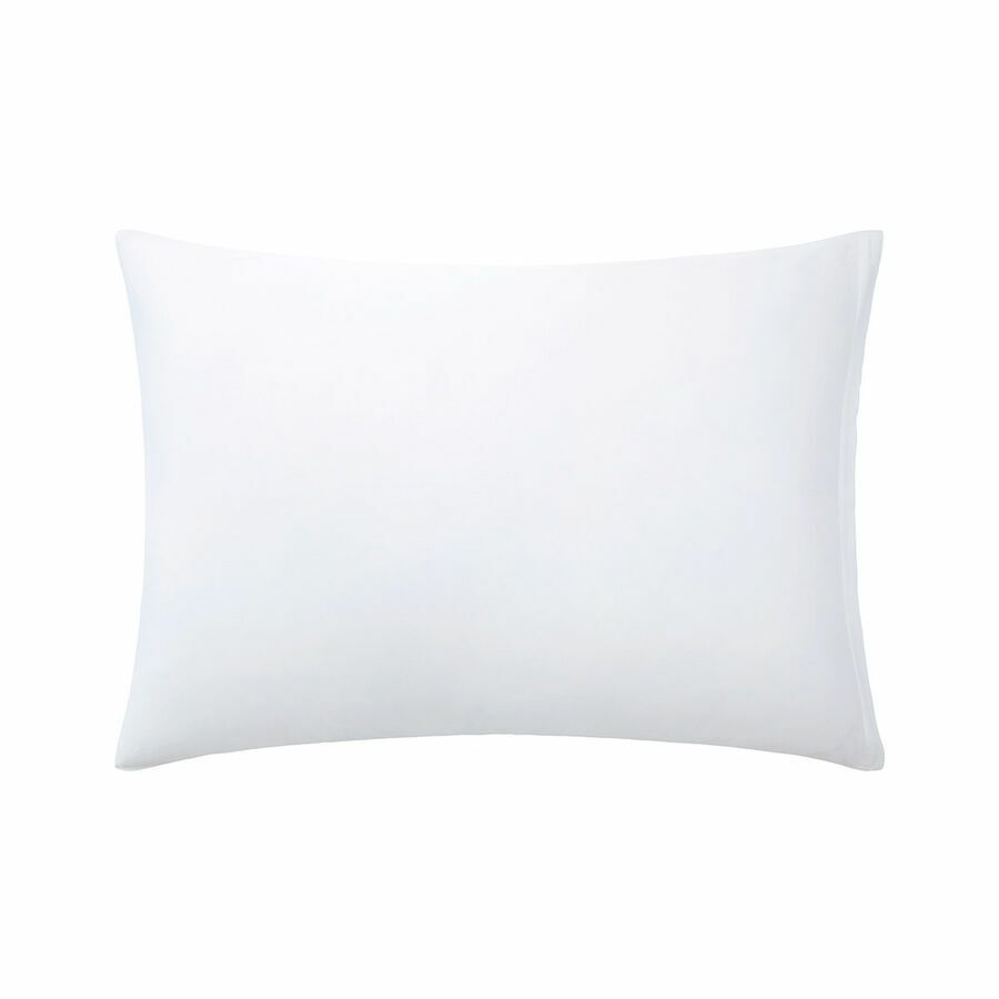 Un oreiller blanc est posé sur une surface blanche.