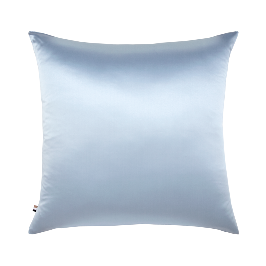 Un oreiller bleu clair est posé sur une surface blanche.