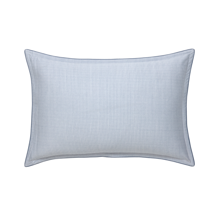 Un coussin rayé bleu et blanc sur fond blanc.