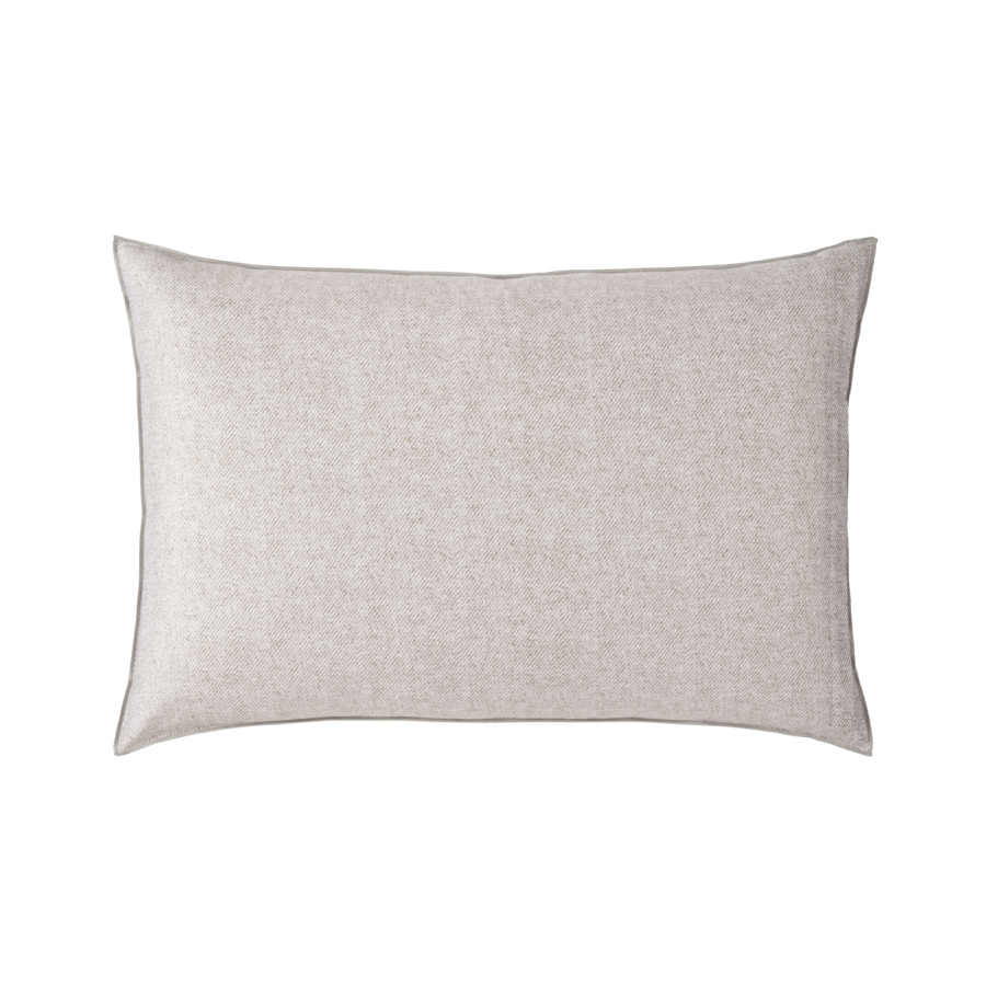 Un oreiller blanc est posé sur une surface blanche.