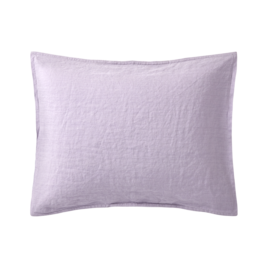 Un oreiller violet est posé sur une surface blanche.