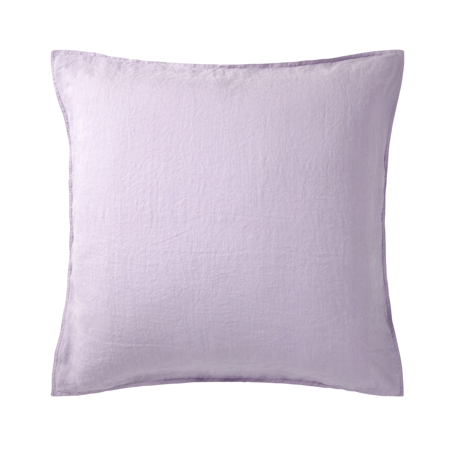 Un oreiller violet est posé sur une surface blanche.