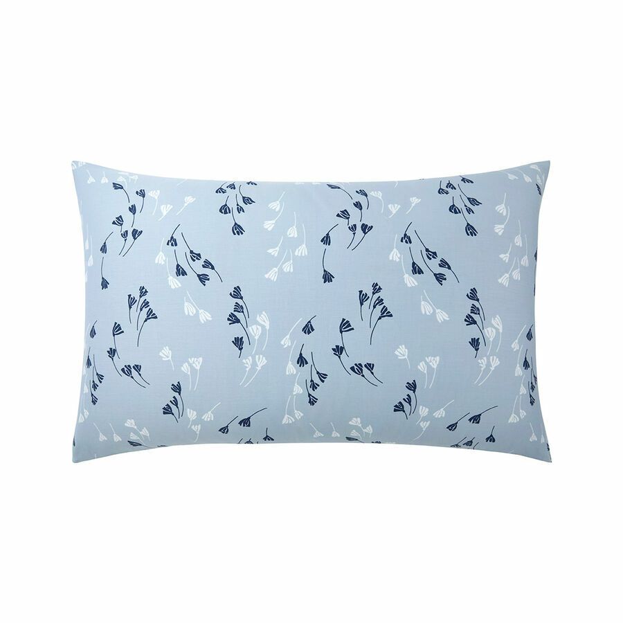 Une taie d'oreiller rectangulaire bleu clair ornée d'un motif répétitif de petites tiges de fleurs foncées et blanches.