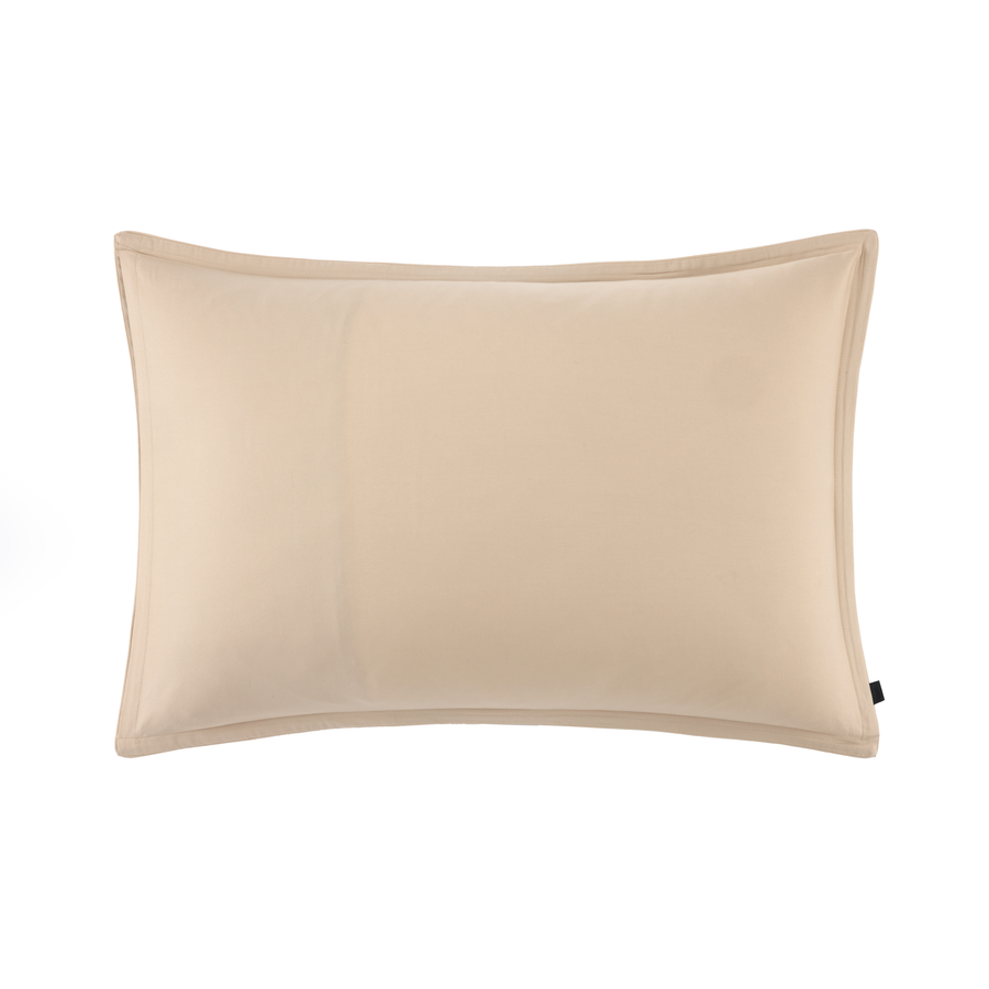 Un coussin rectangulaire uni beige clair avec une bordure en tissu plat, centré sur un fond blanc.