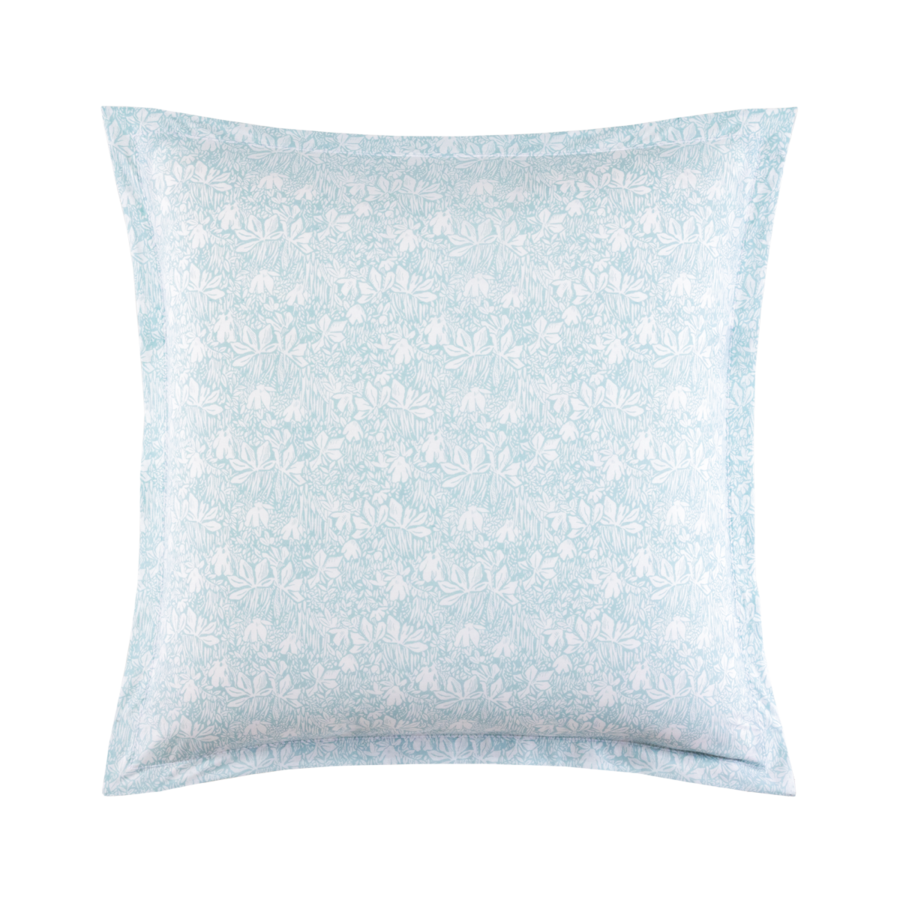 Un coussin décoratif carré orné d'un motif damassé floral bleu clair et blanc avec une large bordure en tissu.