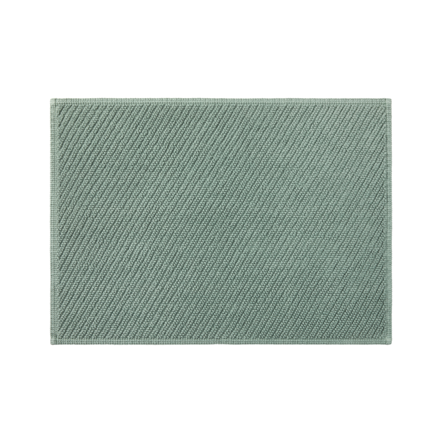Un tapis de bain vert avec un motif dessus sur fond blanc.